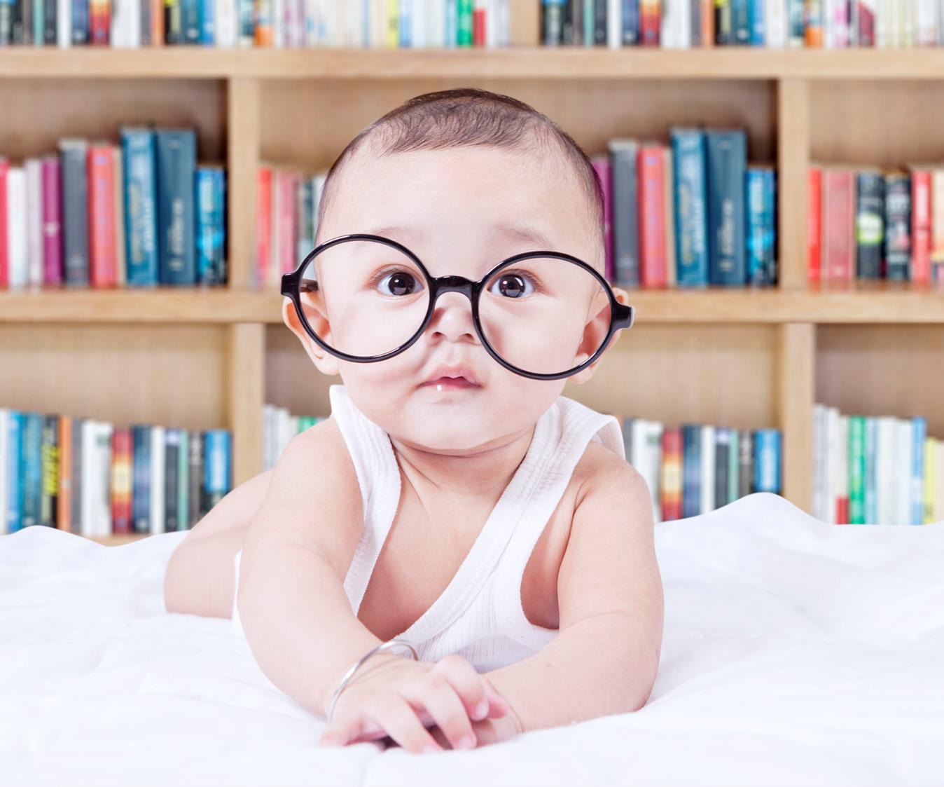 Baby mit Brille vor Bücherregal